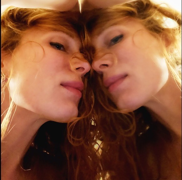 Elena leaning her head against a mirror in a quiet, reflective portrait